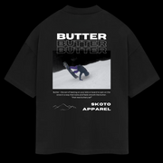 Back of Skoto Butter Tee – black t-shirt featuring skier buttering on snow with bold white “Butter” text and Skoto Apparel branding