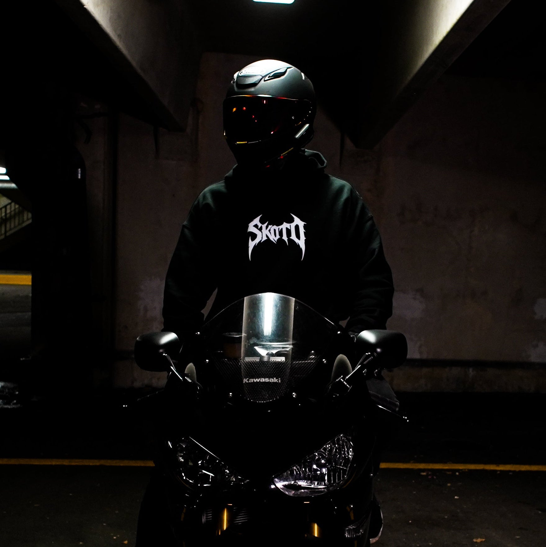 A rider wearing the AUXESIS hoodie with a Kawasaki in the Skoto Field