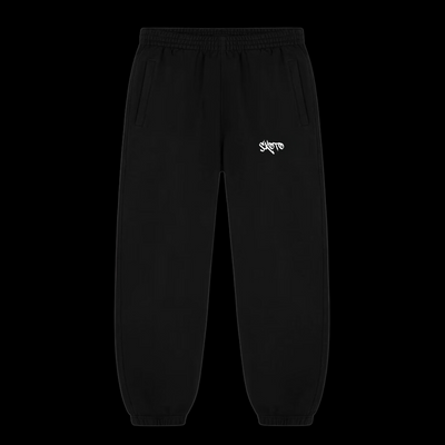 Skoto Short Fit Pants – black tapered sweatpants with white graffiti logo, elastic cuffs, and relaxed streetwear fit